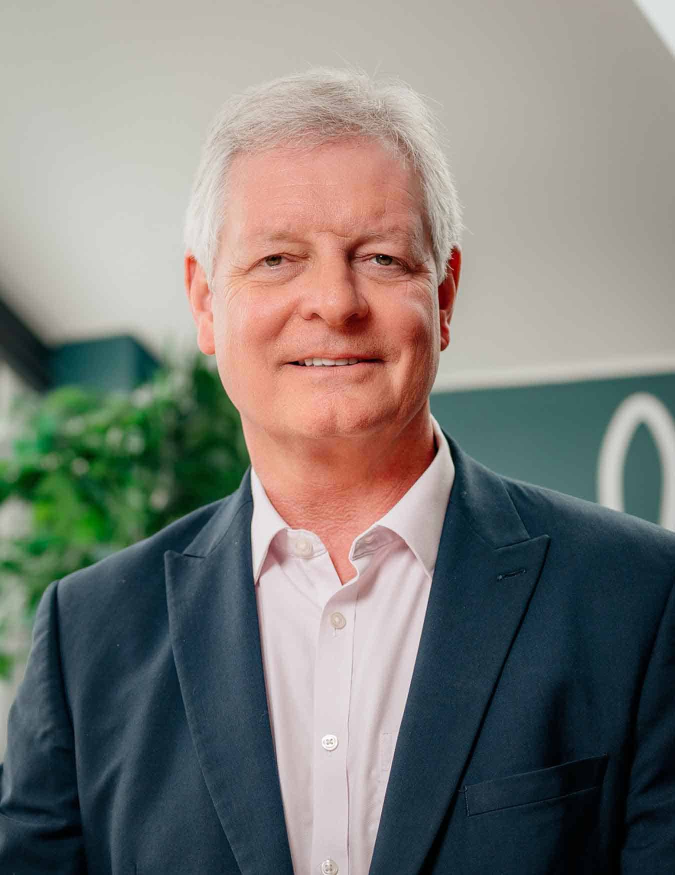 Ophthalmology surgeon Andrew Luff (Andy Luff) in a suit smiling at camera