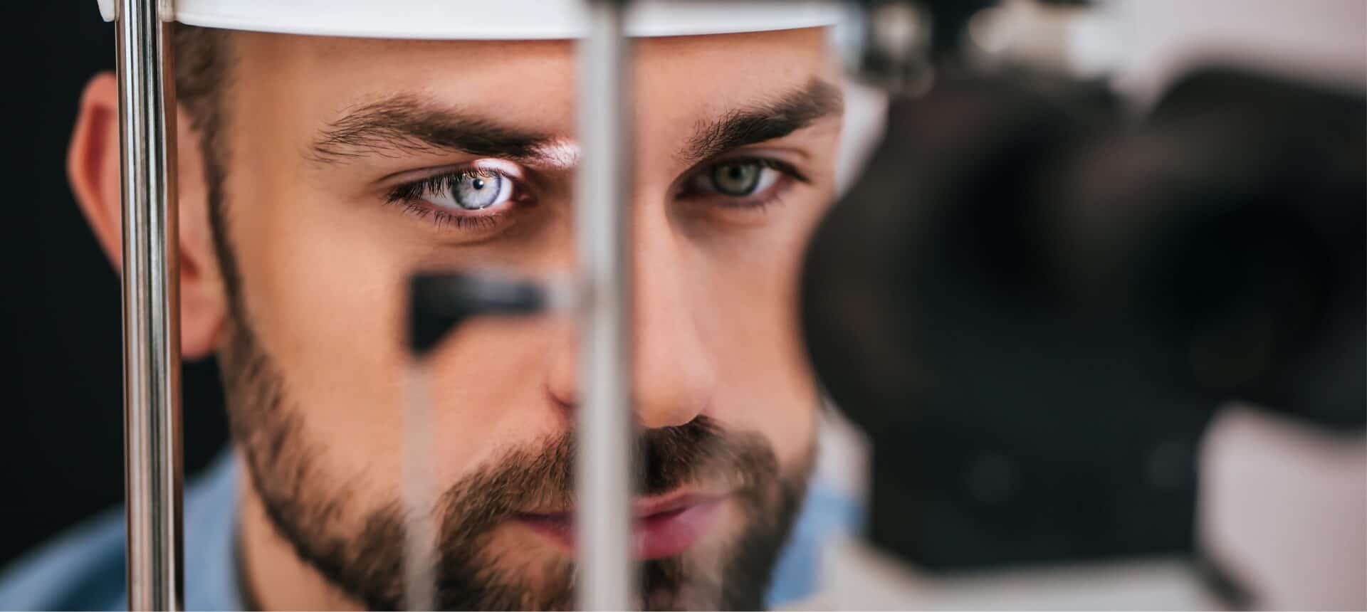 A young man having his right eye examined by an ophthalmologist for eye health relating to floaters