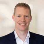 Ophthalmology surgeon Simon Rogers in suit smiling at camera
