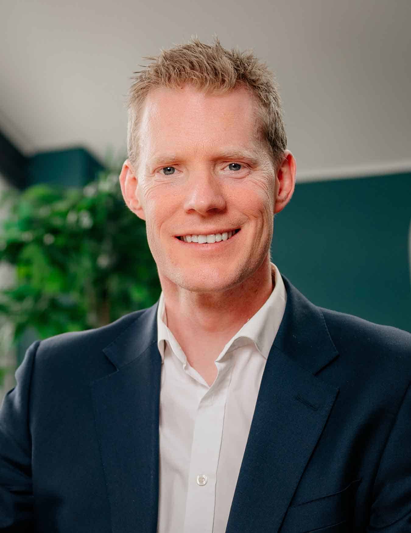 Ophthalmology surgeon Simon Rogers in suit smiling at camera